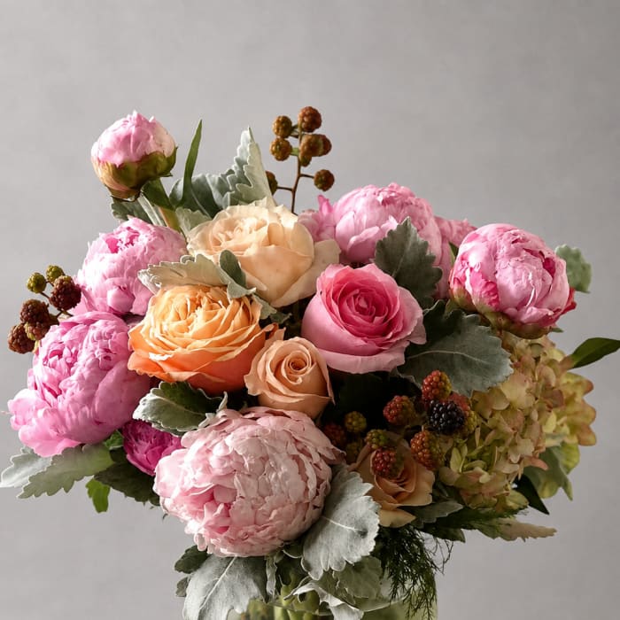 Pink and peach roses arranged in a clear glass vase