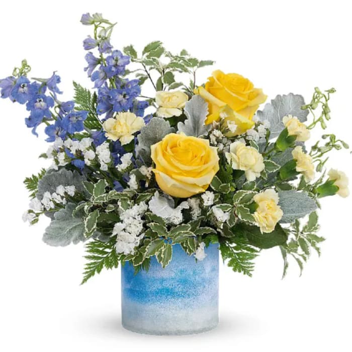 Yellow roses and blue delphinium in a blue glass vase