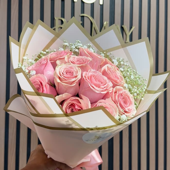 Pink roses wrapped in white and gold paper