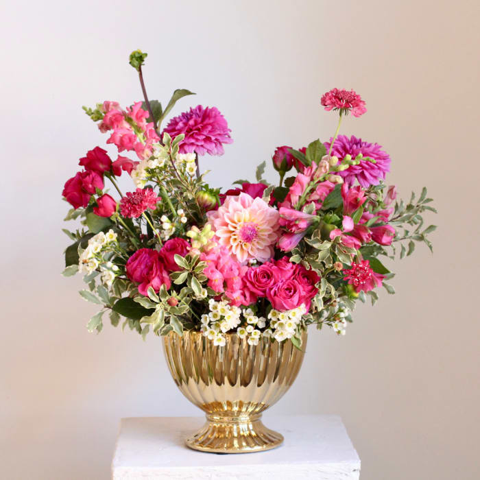 Pink and white mixed flower arrangement in a gold vase