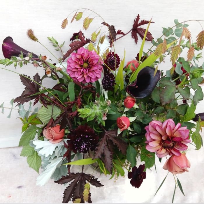 Mixed bouquet with pink dahlias, dark calla lilies, and roses