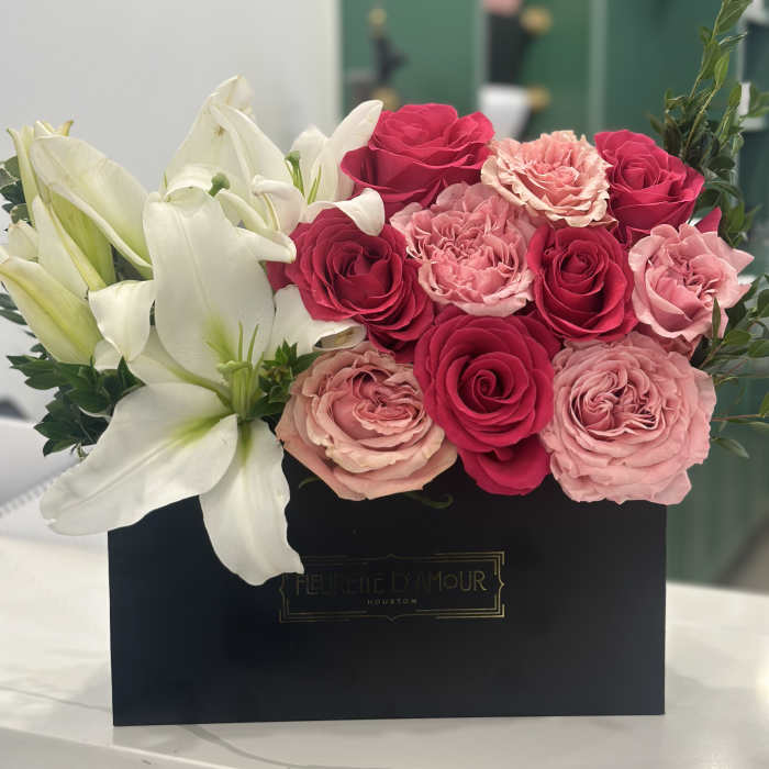 Pink and white roses with white lilies in a black box