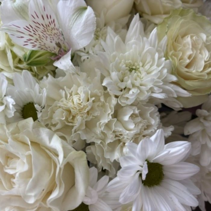 White bouquet with roses, daisies, and ruffled blooms