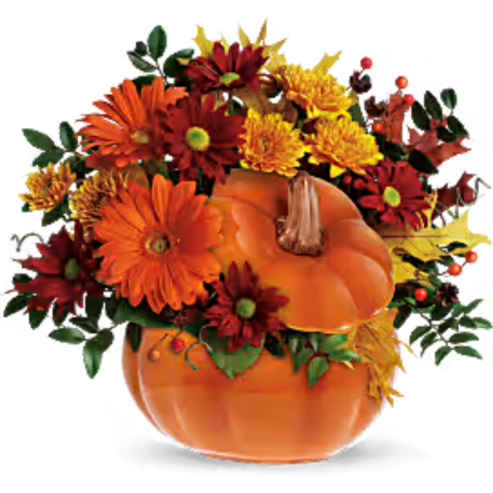 Orange pumpkin filled with orange, red, and yellow flowers