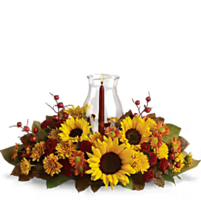 Autumn floral centerpiece with sunflowers around a glass candle holder