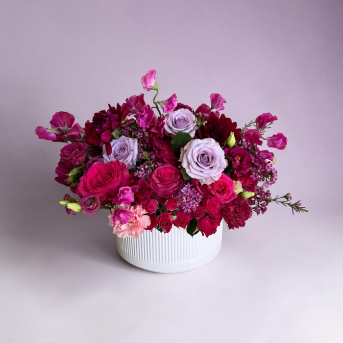 Pink and lavender rose bouquet in a white ribbed vase