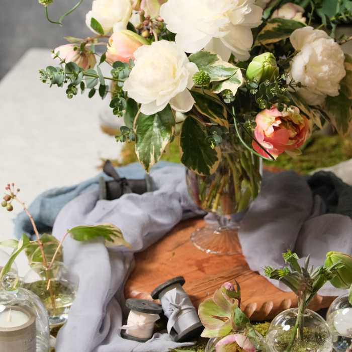 White and blush flowers arranged in a clear glass vase