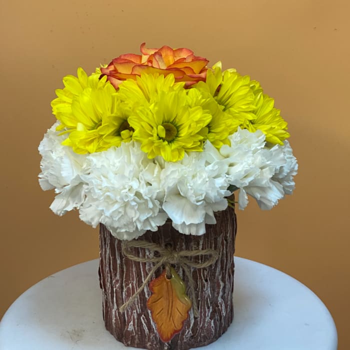 Yellow and white flowers with an orange rose in a rustic vase