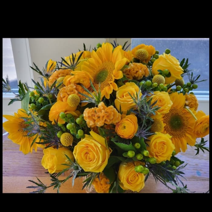 Yellow bouquet with sunflowers and roses in a vase