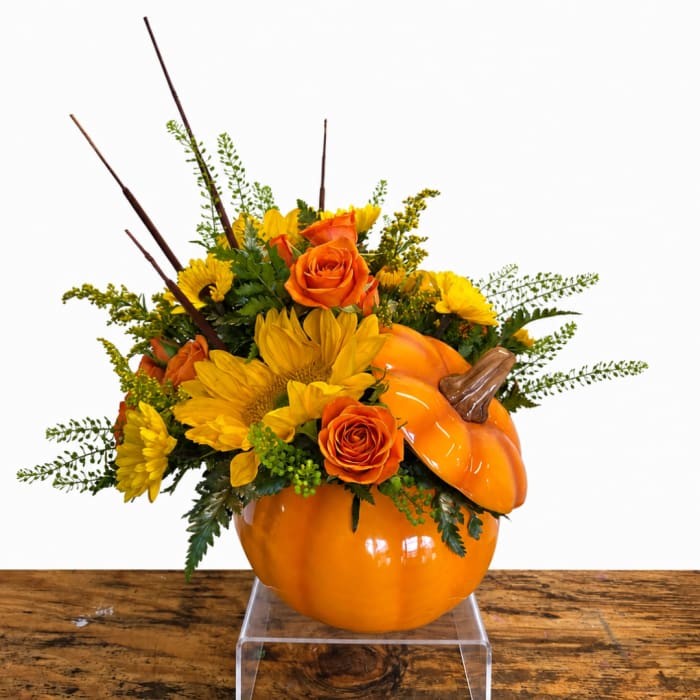 Orange pumpkin vase with yellow flowers and orange roses