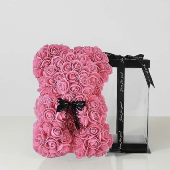 Pink rose teddy bear with a black ribbon on a display stand