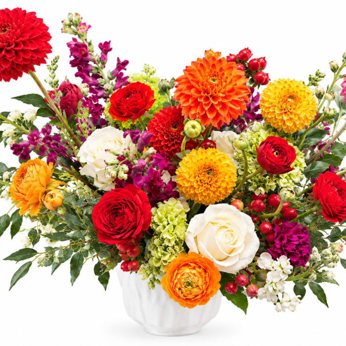 Colorful mixed bouquet in a white vase with roses and dahlias