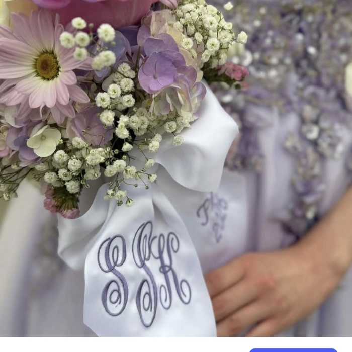 Pastel bouquet with a pink rose, daisy, and baby’s breath tied with a white ribbon