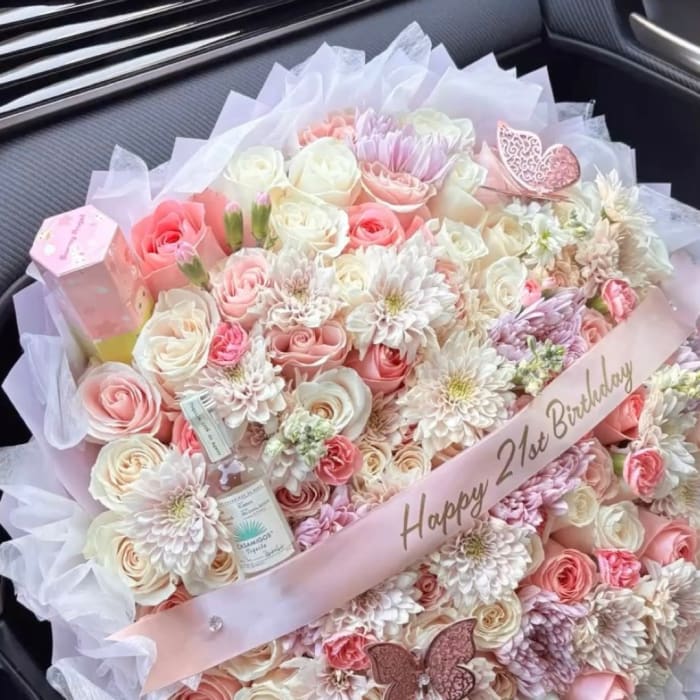 Pink and white bouquet with roses and daisies, wrapped with a birthday ribbon