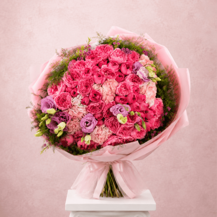 Pink bouquet of roses and lisianthus wrapped in pale pink paper