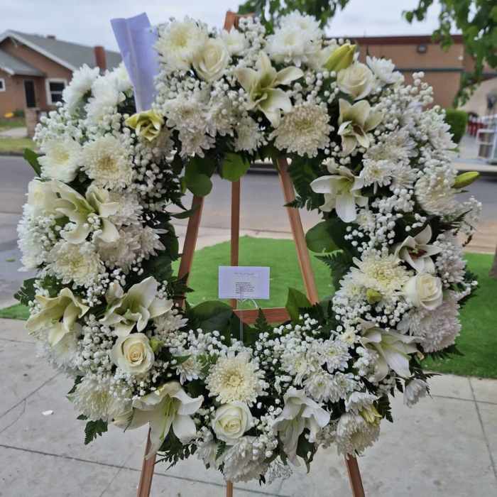 Large white floral wreath on a wooden easel
