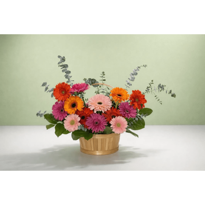 Basket of colorful gerbera daisies with eucalyptus accents