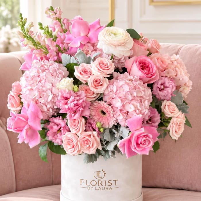 Pink and white flower arrangement in a white hat box