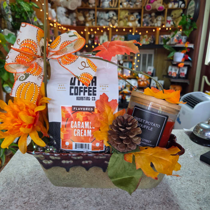 Gift basket with coffee, a candle, and autumn decorations