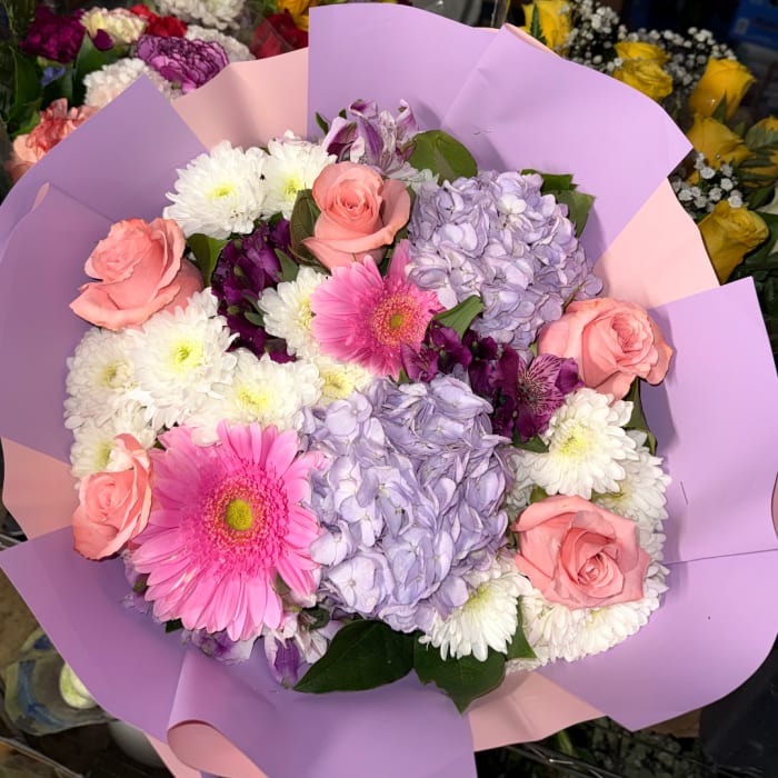 Bouquet of pink roses, lavender hydrangeas, white chrysanthemums, and pink gerbera daisies