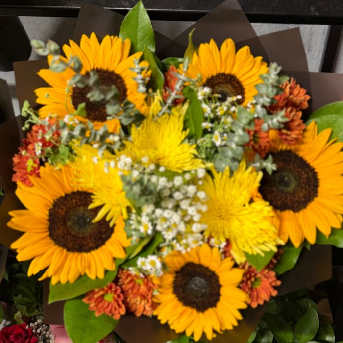 Bouquet of sunflowers and yellow mums with small white filler flowers