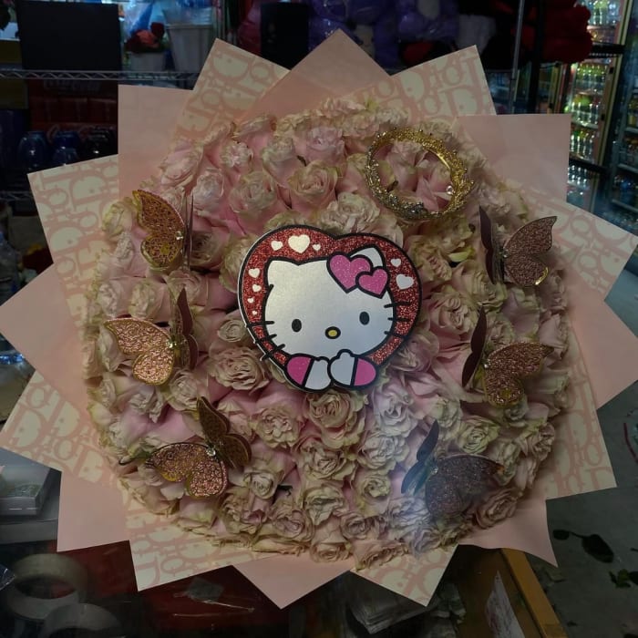Pink rose bouquet with a Hello Kitty topper and butterfly decorations