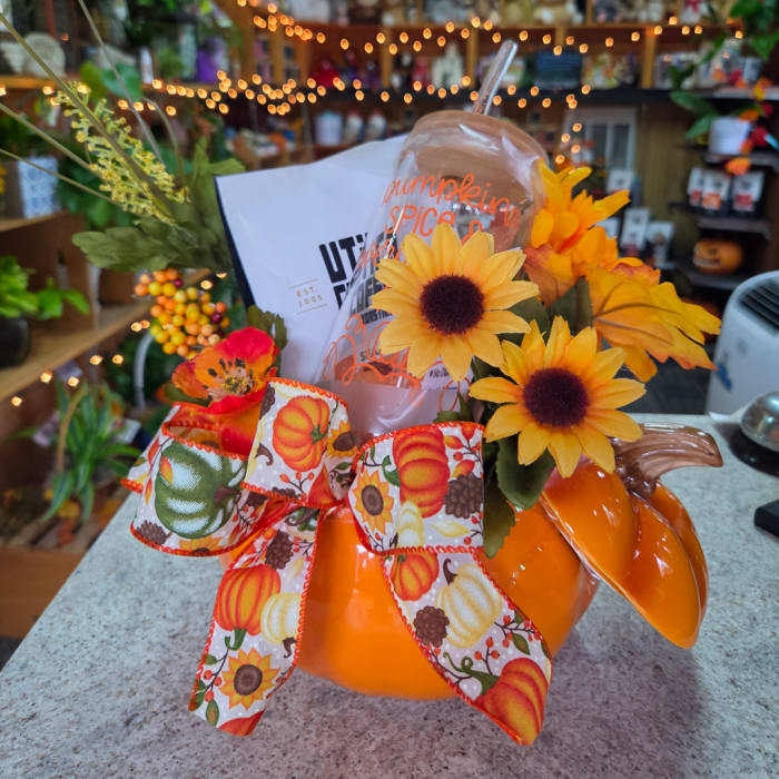 Pumpkin-shaped floral arrangement with sunflowers and a fall ribbon bow