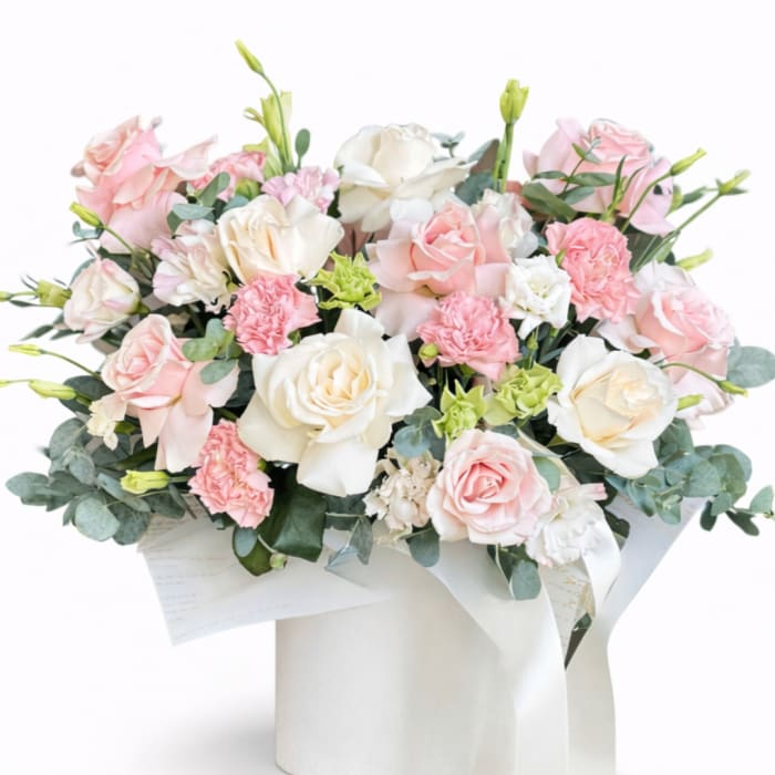 Bouquet of pink and white roses with carnations in white wrap