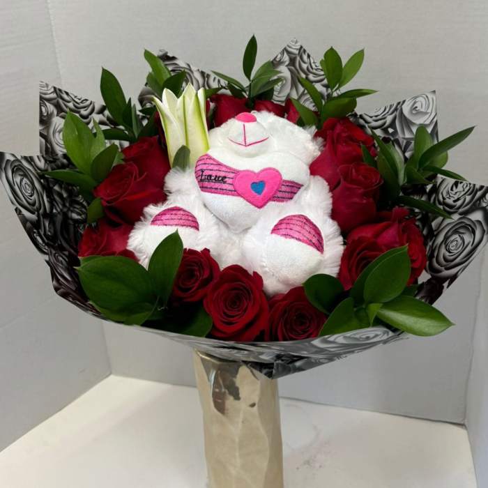 Bouquet of red roses with a white teddy bear in the center