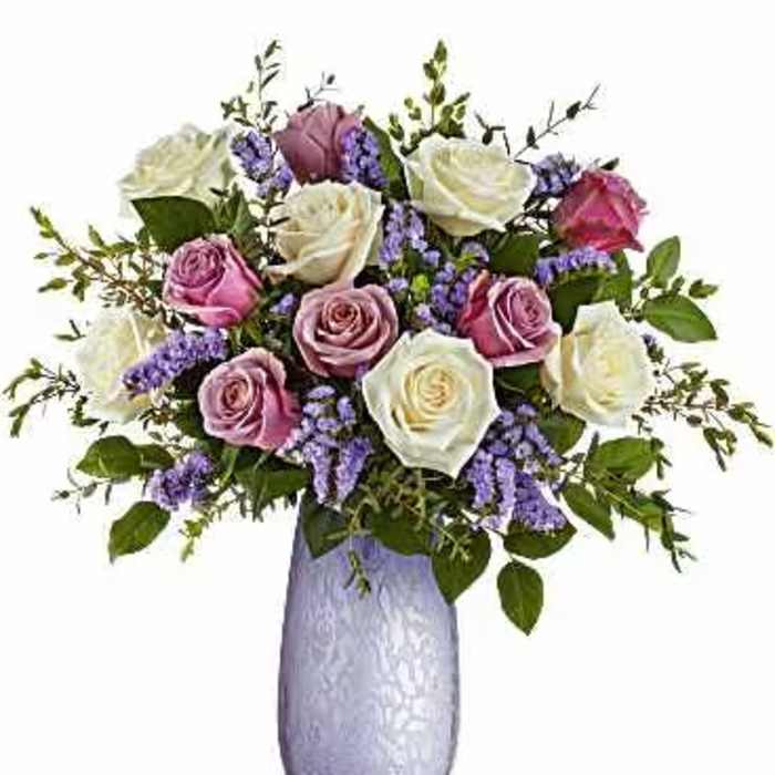 Bouquet of pink and white roses in a lavender vase