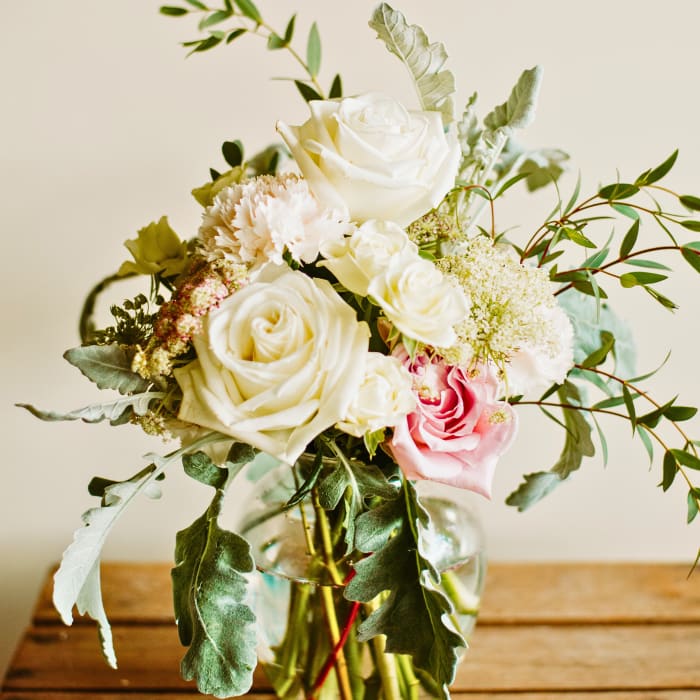 Bouquet of white and pink roses in a clear glass vase