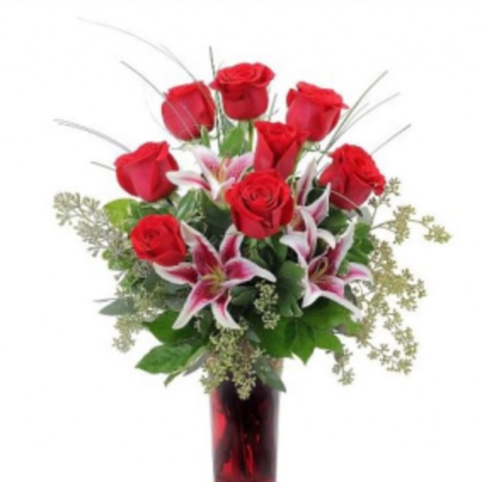 Red roses and pink lilies in a red glass vase