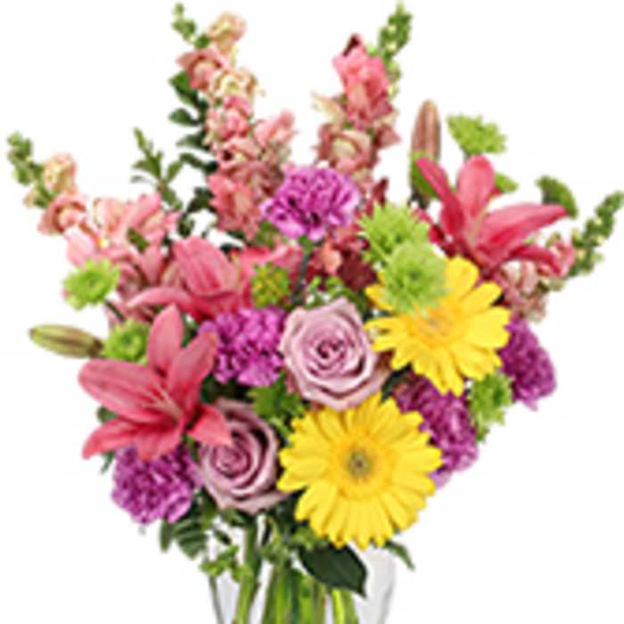 Mixed pink and yellow flowers in a clear glass vase
