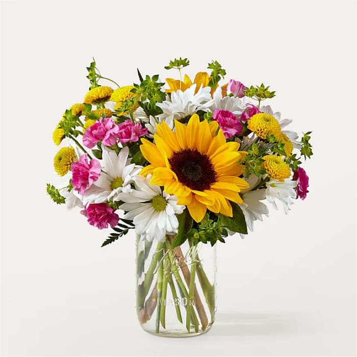 Sunflower and daisy bouquet in a clear glass vase