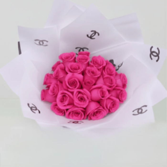 Bouquet of bright pink roses wrapped in white paper
