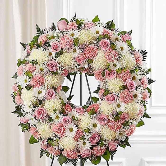 Pink and white floral wreath on a black easel