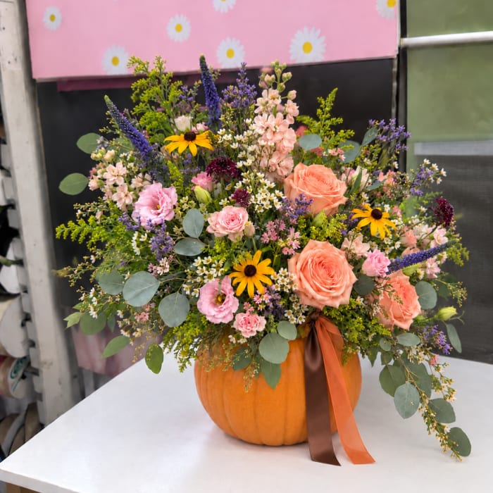 Mixed bouquet in a pumpkin vase with peach and pink flowers