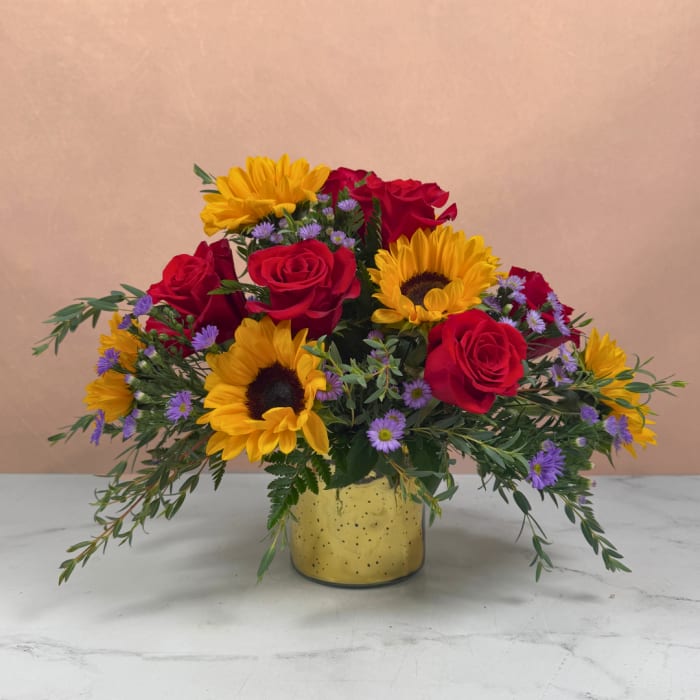 Bouquet of red roses and yellow sunflowers in a yellow vase