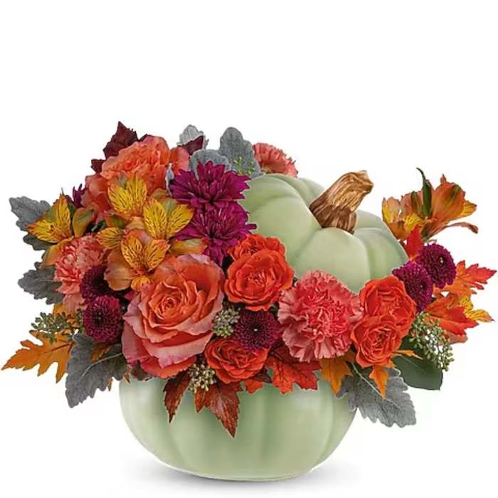 Autumn floral arrangement in a pale green pumpkin vase