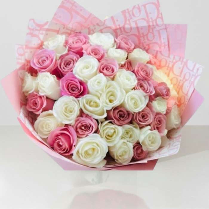 Bouquet of pink and white roses wrapped in pink paper