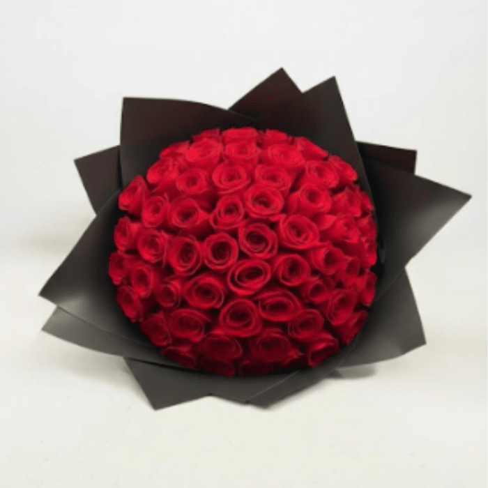 Round bouquet of red roses wrapped in black paper