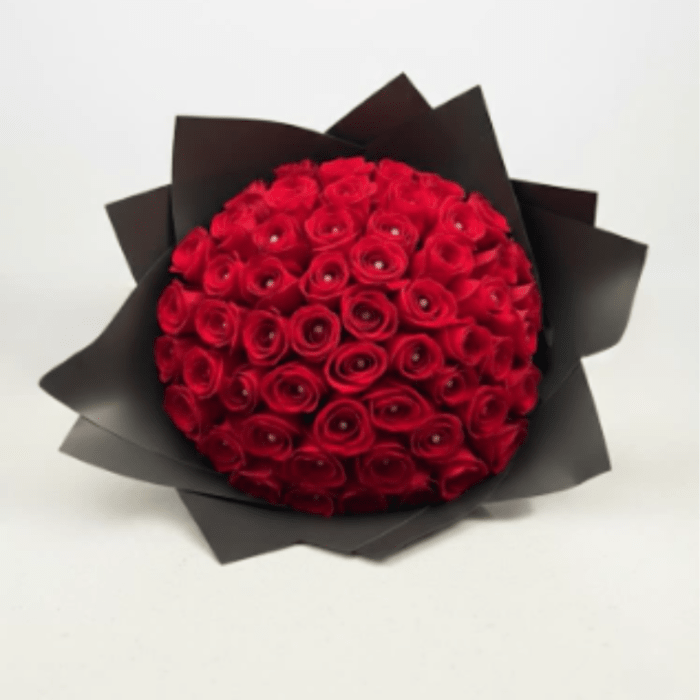 Round bouquet of red roses wrapped in black paper
