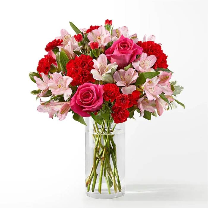 Pink roses and red carnations in a clear glass vase