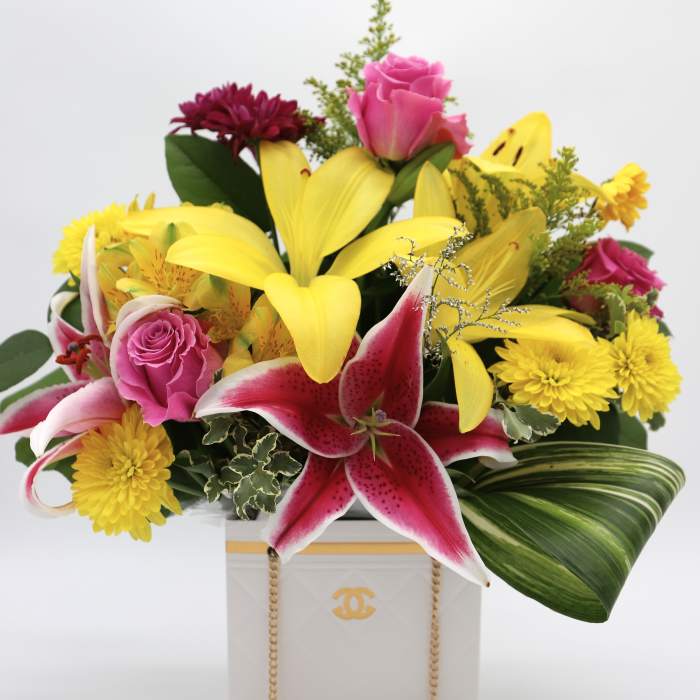 Mixed bouquet with yellow lilies, pink roses, and chrysanthemums in a white box