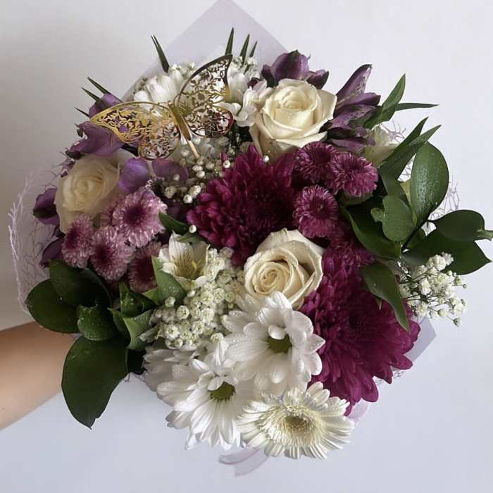 Handheld bouquet of white, purple, and pink flowers with a butterfly pick