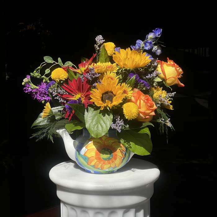 Bright mixed bouquet in a painted ceramic pitcher