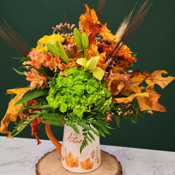 Autumn bouquet in a white mug with orange handle and leaf print