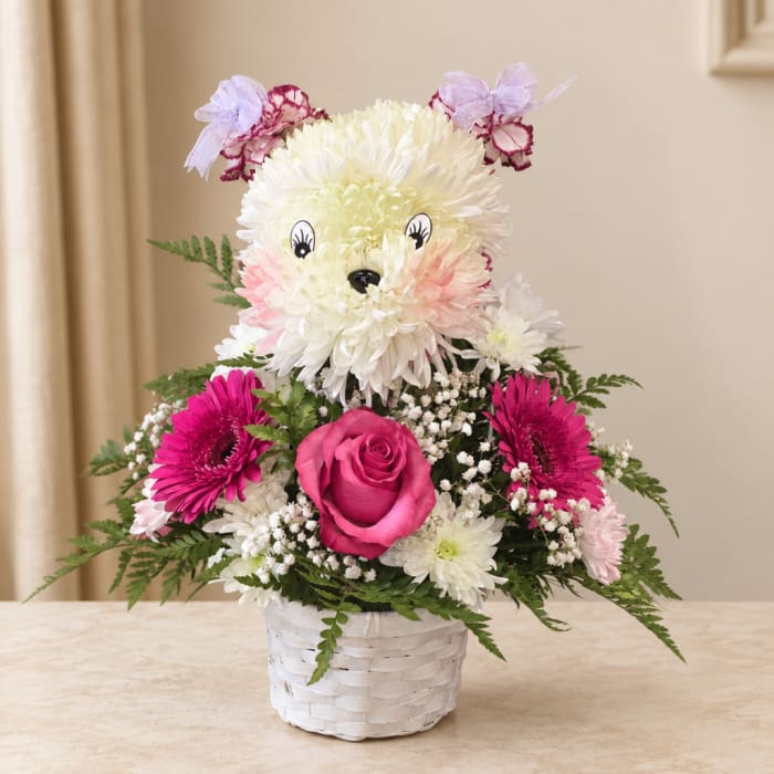 Flower arrangement shaped like a teddy bear in a white basket
