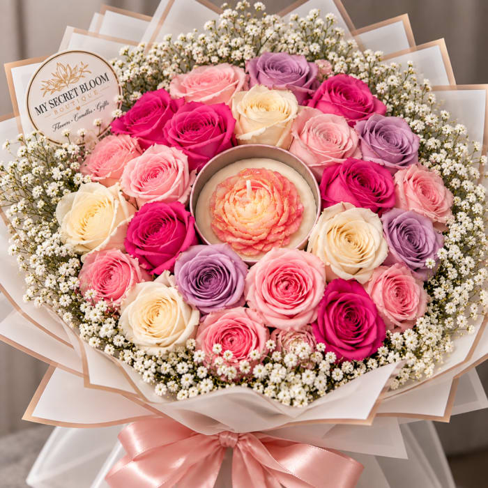 Bouquet of pink, cream, and lavender roses around a flower-shaped candle