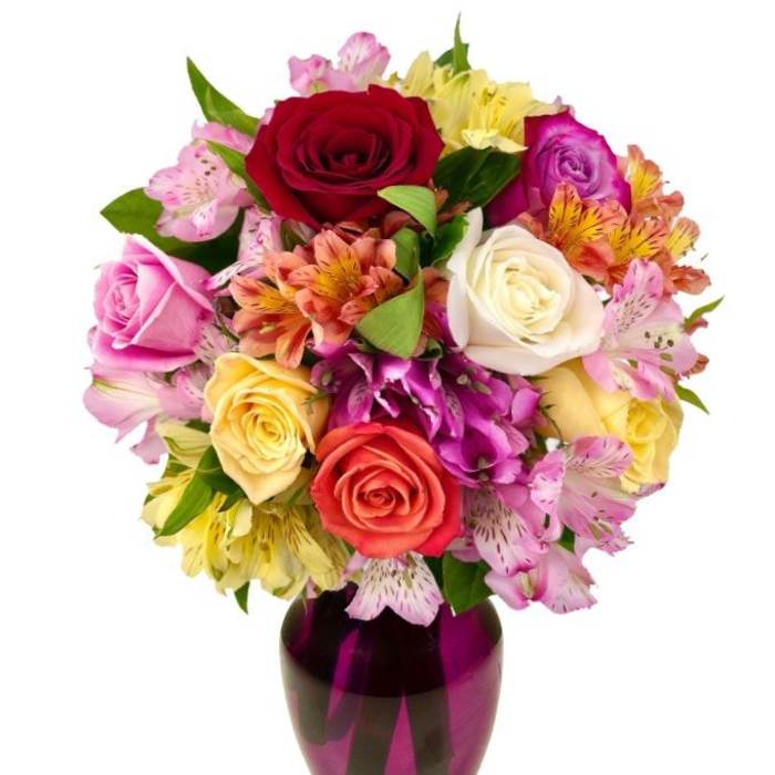 Mixed bouquet of roses and alstroemeria in a purple vase